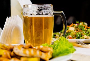 Mug of Beer on Restaurant Table with Plated Food