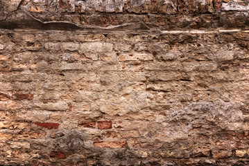 old brick wall with loose bricks and deteriorating mortar