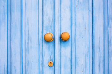 Naklejka na ściany i meble Yellow door knob on the blue wooden door. Mediterranean style.