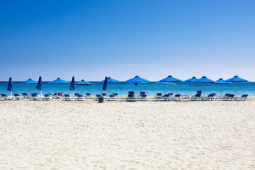 Fototapeta na wymiar Many beach chairs and umbrellas on white sand sea beach,blue sky