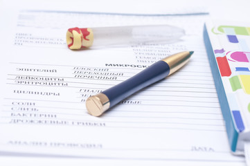 Filling in the blood test blank with a pen and next  vial