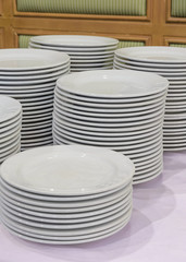 Piled up of white plates on table