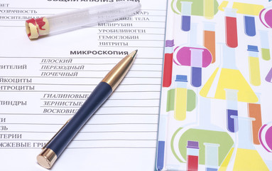 Filling in the blood test blank with a pen and next  vial