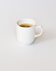 White Cup of Hot Coffee on Gray Background.