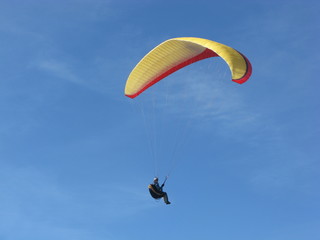 Parapente jaune et rouge en vol