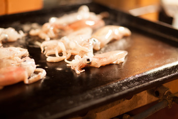 squids grilling on metal plate