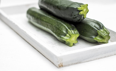 Zucchinis auf Weißen Holztablett