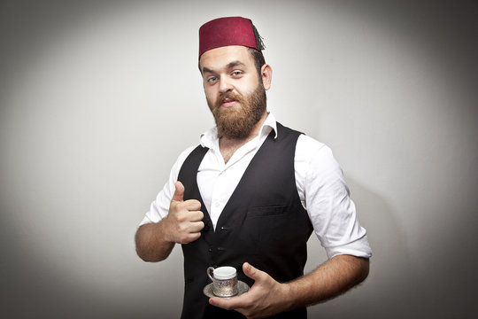 Man in traditional turkish hat dress kabadayi drinking coffee
