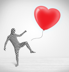 Fototapeta premium Cute guy in morpsuit body suit looking at a balloon shaped heart