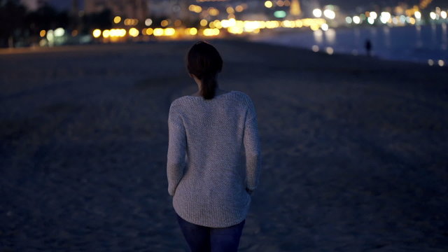 Attractive woman walking on beach at night