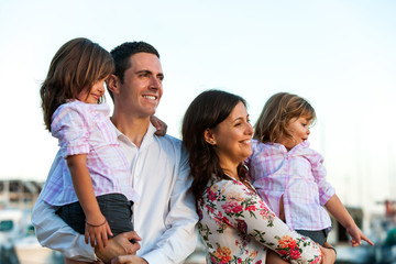 Young family with daughters at sunset.