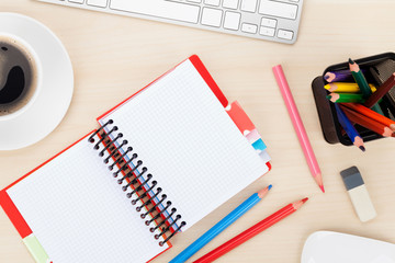 Office table with computer, supplies and coffee cup