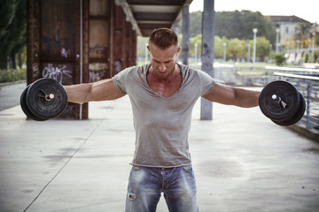 Attractive Muscular Hunk Man Lifting Weights Outdoor