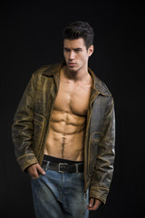 Naklejka na ściany i meble Handsome young man wearing leather jacket on naked torso