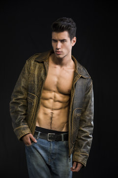 Handsome young man wearing leather jacket on naked torso