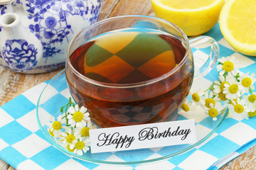 Happy birthday card with cup of tea and chamomile flowers