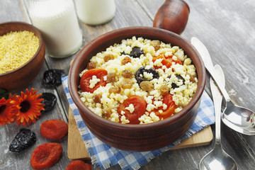 Millet porridge with dried apricots and prunes in a bowl