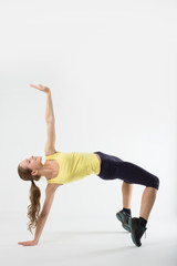 Naklejka premium Young athletic girl makes gymnastic bridge