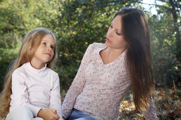 Conversation mother and daughter in the autumn park