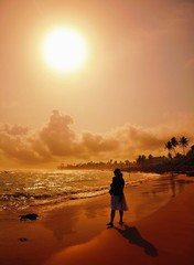 Fototapeta premium Woman on beach at sunset.