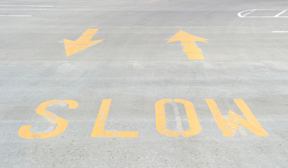 Painted slow sign with arrows on concrete