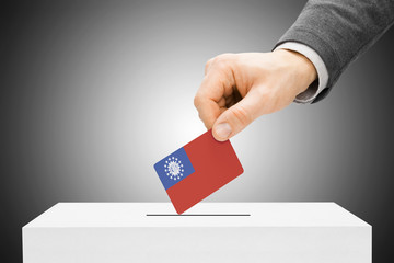 Voting concept - Male inserting flag into ballot box - Burma