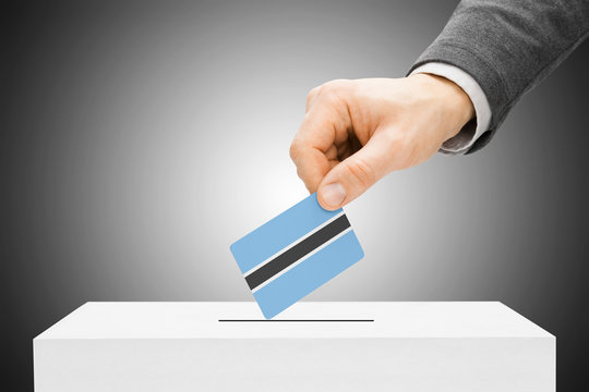 Voting concept - Male inserting flag into ballot box - Botswana