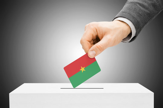 Male inserting flag into ballot box - Burkina Faso