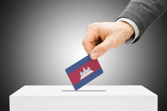 Voting concept - Male inserting flag into ballot box - Cambodia