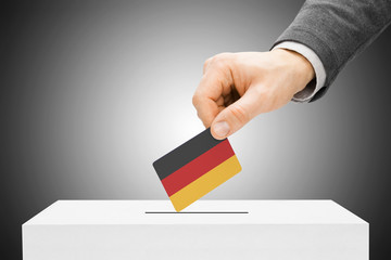 Voting concept - Male inserting flag into ballot box - Germany