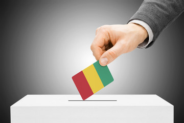 Voting concept - Male inserting flag into ballot box - Guinea