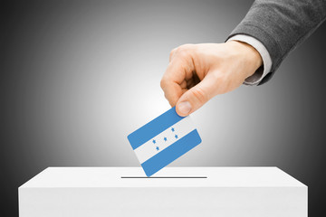 Voting concept - Male inserting flag into ballot box - Honduras