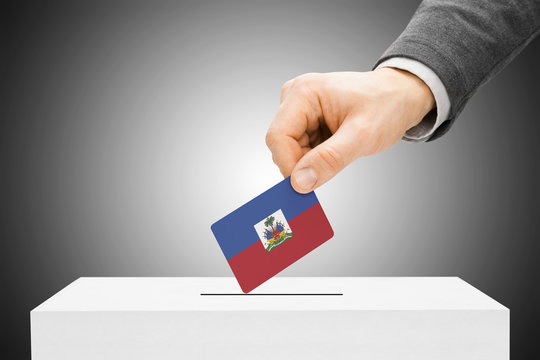 Voting concept - Male inserting flag into ballot box - Haiti