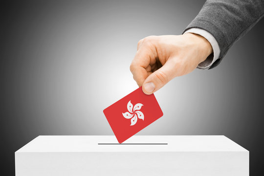 Voting concept - Male inserting flag into ballot box - Hong Kong