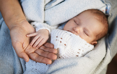 Mom keeps  miniature hand newborn baby in hands