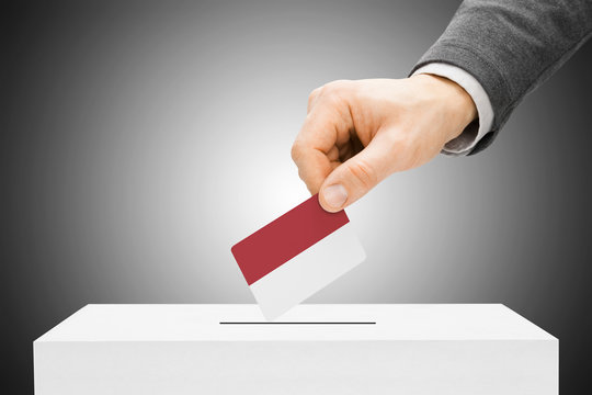 Voting concept - Male inserting flag into ballot box - Monaco