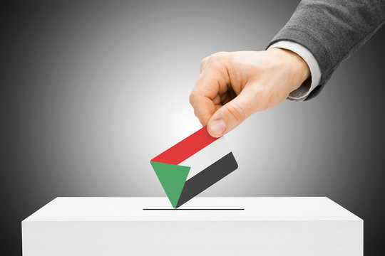 Voting concept - Male inserting flag into ballot box - Sudan