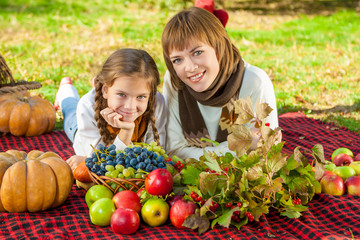 Happy mother with little daughter in autumn park