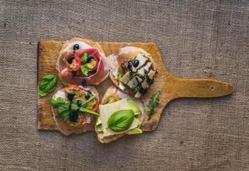 Wall murals Product Range Antipasti brusquetta set on a rustic wooden board over a sackclo