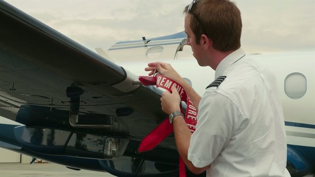 Pilot Attaches Post-Flight Safety Covers Ribbons to Back of Wing