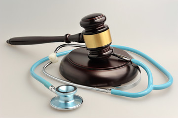 Stethoscope with judge gavel on gray