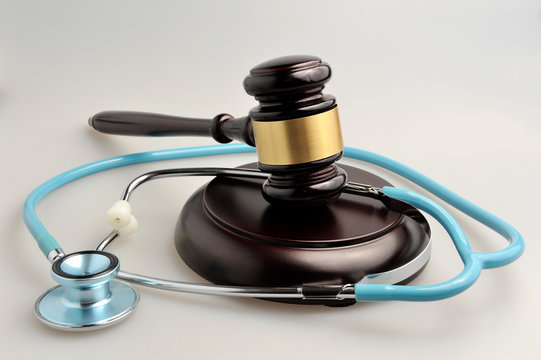 Stethoscope with judge gavel on gray