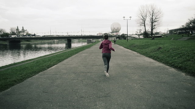 Woman jogging by the river in the city, super slow motion, 240fp