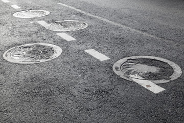 Sewer manholes on asphalt road pavement