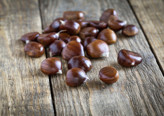 Raw chestnuts on wooden board