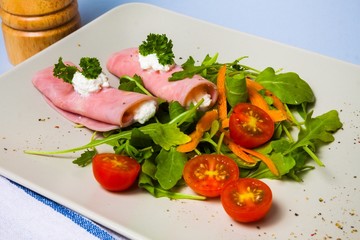 Rolled slices of ham filled with horseradish cream on plate