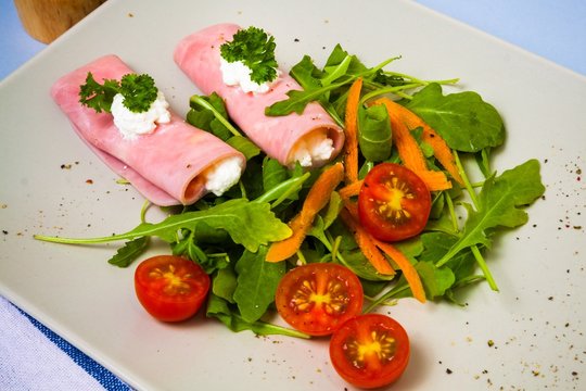 Rolled slices of ham filled with horseradish cream on plate