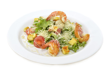 Salad with shrimps and vegetables on white plate isolated