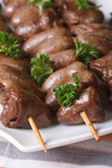 Grilled chicken hearts on skewers  macro, vertical top view