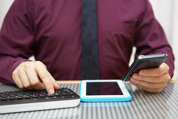 busy businessman is working on computer, tablet and mobile phone